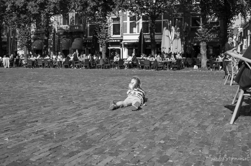 Meisje rust uit op Plein Den Haag na afloop initiatief van Liesje Doet voor de vluchtelingenproblematiek, straatfotografie Sandra Stokmans