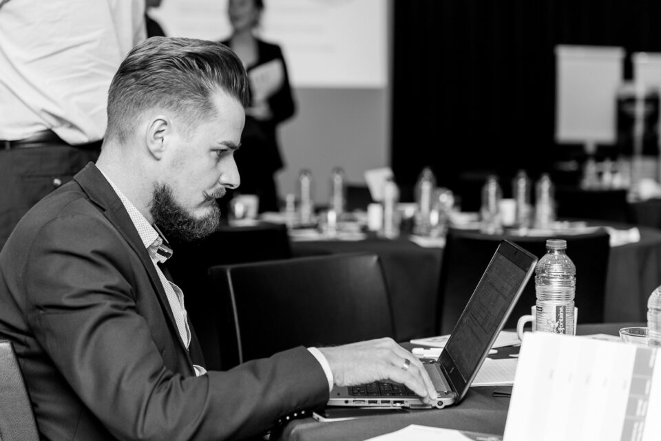 Een werkende zakenman met laptop tijdens het maken van een evenement reportage. Evenement fotografie, zakelijke fotografie, bedrijfsfotografie, image by Sandra Stokmans Fotografie