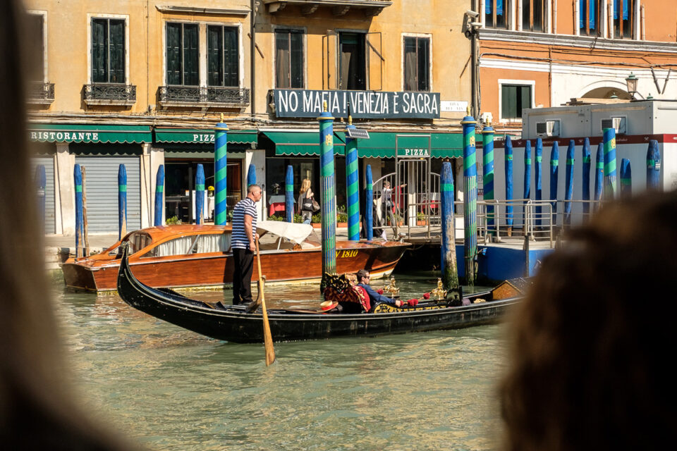 Bord dat zegt Geen Maffia, Venetië is heilig terwijl er gondela rit onder plaatsvind, Italië, reisfotografie Sandra Stokmans Fotografie