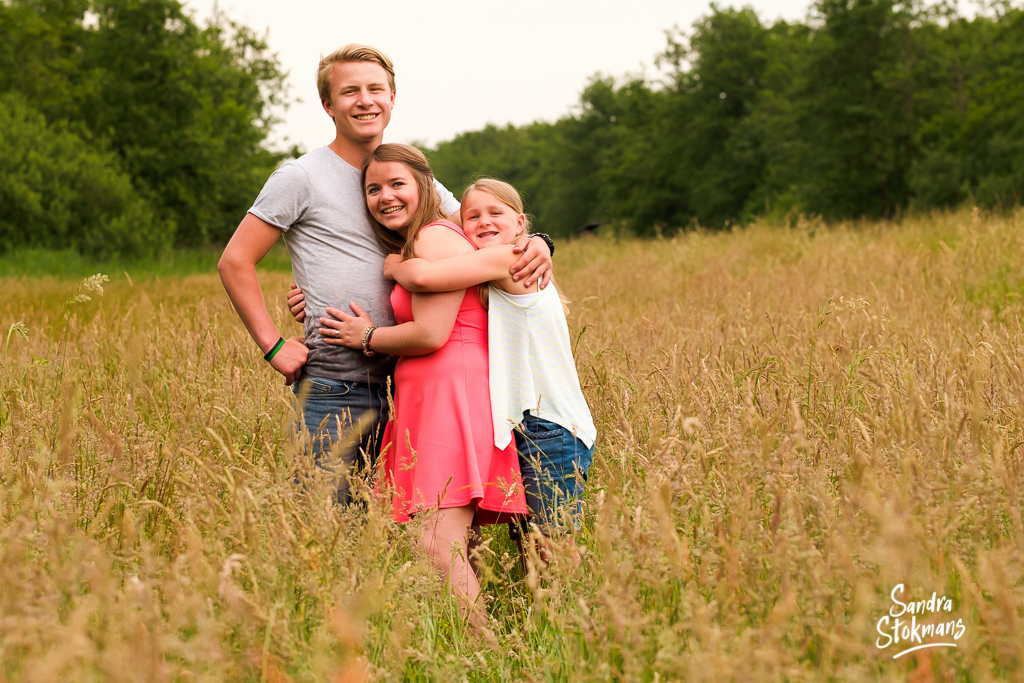 Familie shoot voor een vaderdag cadeau, foto van zussen en broer in een open veld, familie fotografie, foto door Sandra Stokmans Fotografie