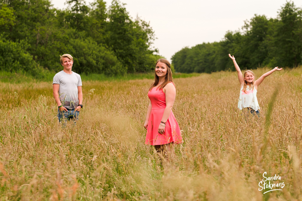 Familie shoot voor een vaderdag cadeau, foto van zussen en broer in een open veld, familie fotografie, foto door Sandra Stokmans Fotografie