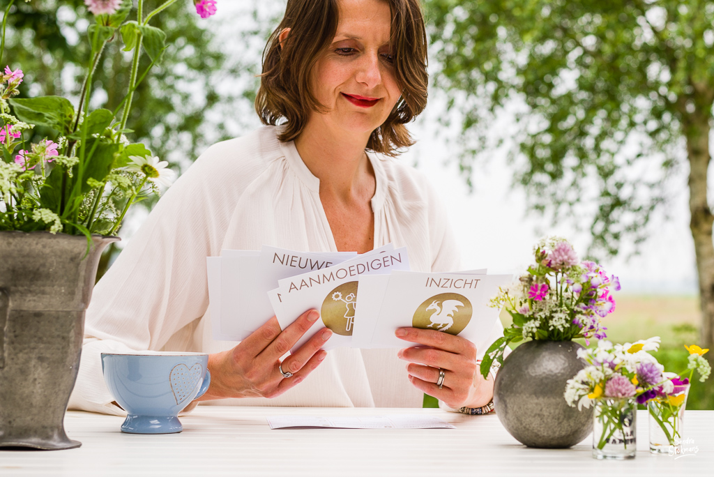 Buiten aan tafel close-up, gebruikmakend van het kaartspel de Assen van Verandering, foto's voor landingspagina foto door Sandra Stokmans Fotografie