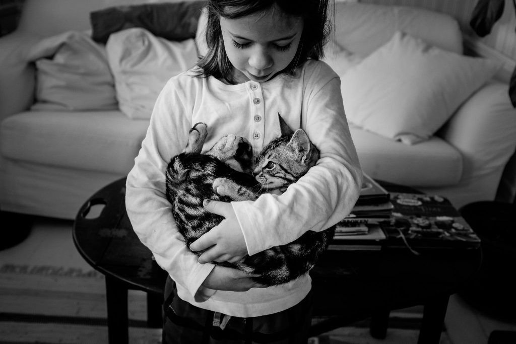 Meisje houdt poes in haar armen alsof het haar kindje is, foto door Caroline Holt, Girl holds kat as if it were her baby