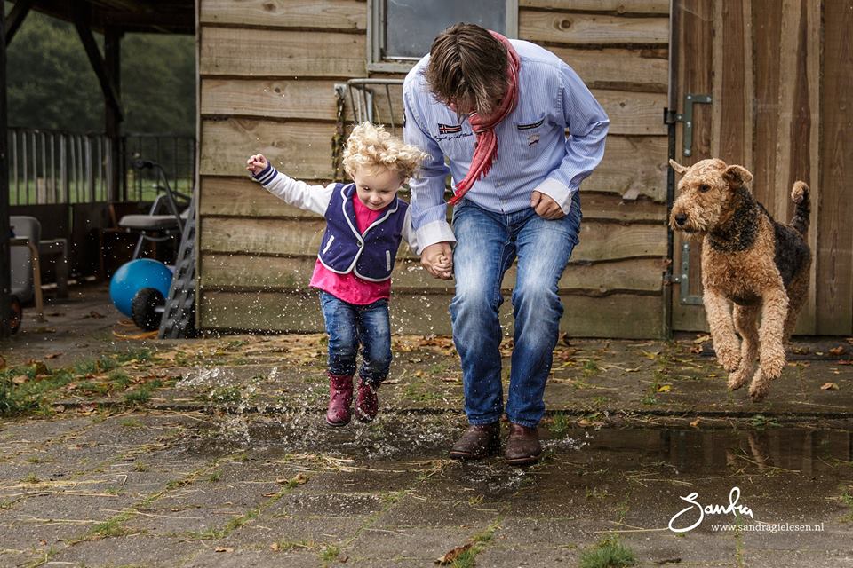 Moeder, kind en hond springen in een plas, foto door Sandra Gielesen-Roeling