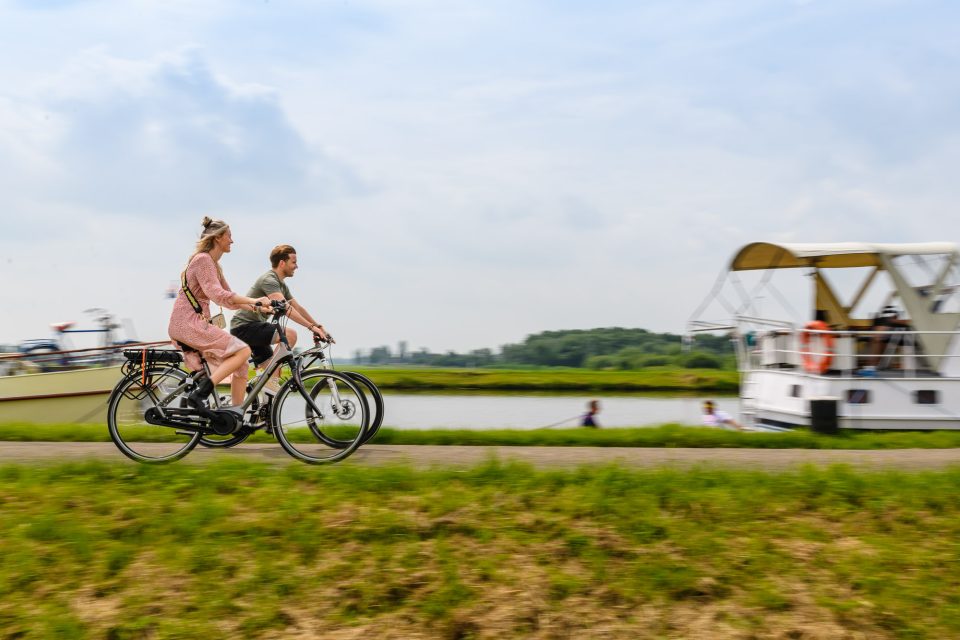 Fietsend koppel in Meerkerk tijdens een documentaire reportage voor de beeldbank van woningcorporatie Fien Wonen