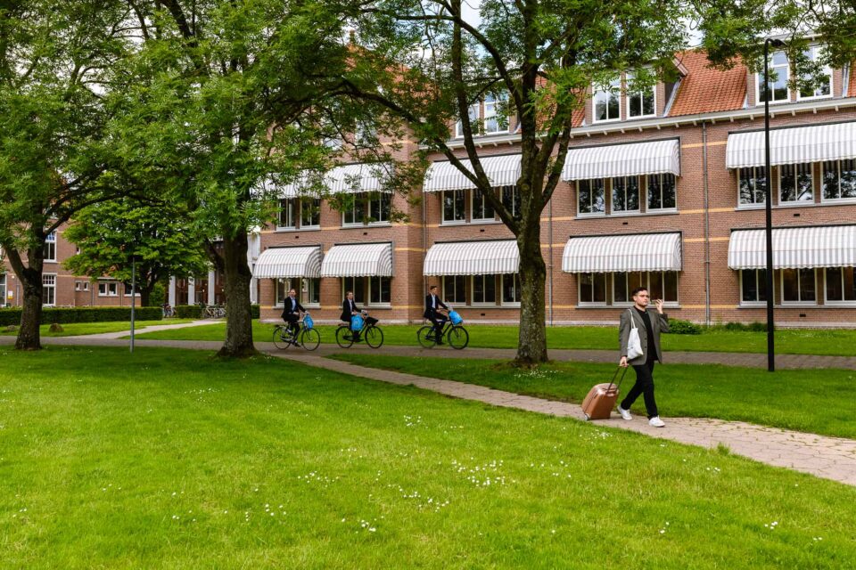 Een echt 'Sandra'-moment! Terwijl ik in mijn ooghoek drie bijna identieke studenten zag fietsen met dezelfde fietsen en Albert Heijn-tassen. En de bonus? De andere jongen die er zo casual bijloopt met koffer pratend in telefoon zoals de jongvolwassenen nu doen! Dit spontane moment voegt een vleugje humor toe aan de universiteit beeldbank.