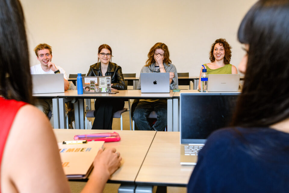 Een superleuk, spontaan moment tijdens een werkcollege aan de Universiteit Utrecht, met lachende studenten in beeld.