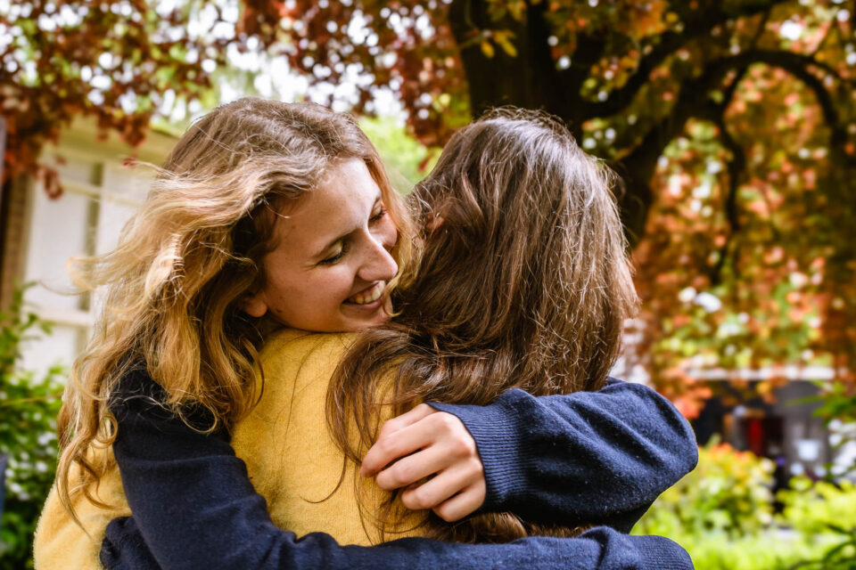 Een spontaan moment van omhelzing tussen studentes vastgelegd voor de beeldbank van de Universiteit Utrecht.
