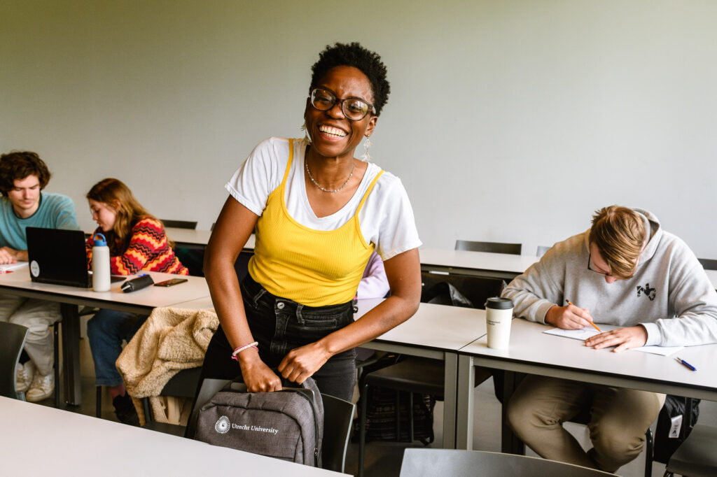 Een portret van een lachende student tijdens het werkcollege. Reportage-fotografie voor de universiteit beeldbank en onderwijsmarketing voor de Universiteit Utrecht.