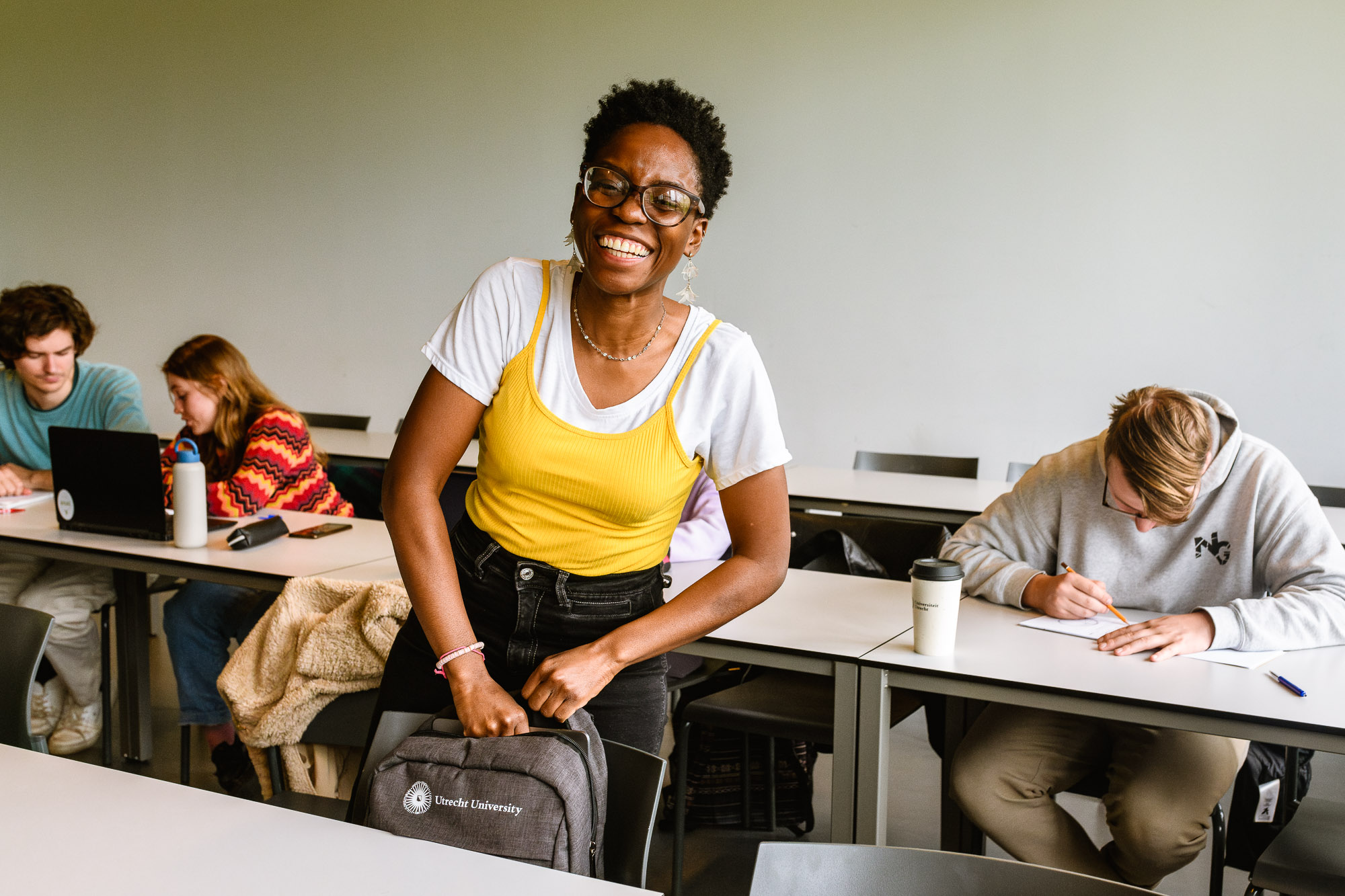 Een portret van een lachende student tijdens het werkcollege. Reportage-fotografie voor de universiteit beeldbank en onderwijsmarketing voor de Universiteit Utrecht.
