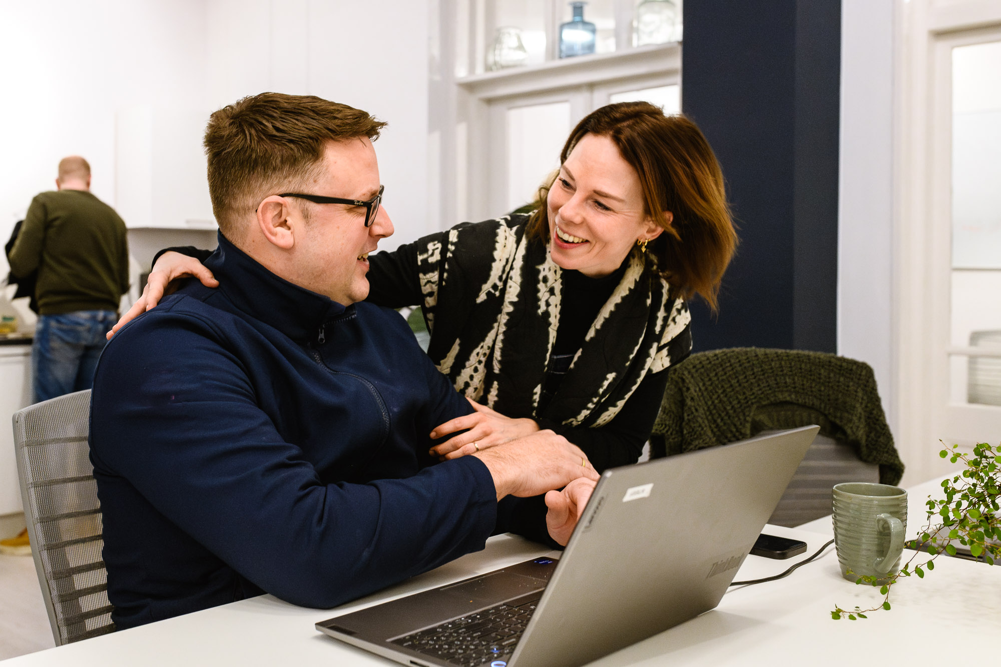 Een vrolijke ochtendbegroeting tussen collega's op kantoor, vastgelegd tijdens een branding kantoorreportage in Amsterdam. Een moment van teamgeest en positiviteit!