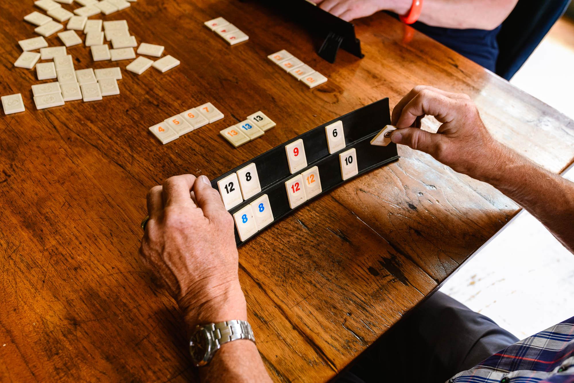 Een detailfoto, zoals hier tijdens een spelletje Rummikub, mag niet ontbreken: het voegt een anonieme, veelzijdige laag toe en is een mooie aanvulling op de variatie in de beeldbank.